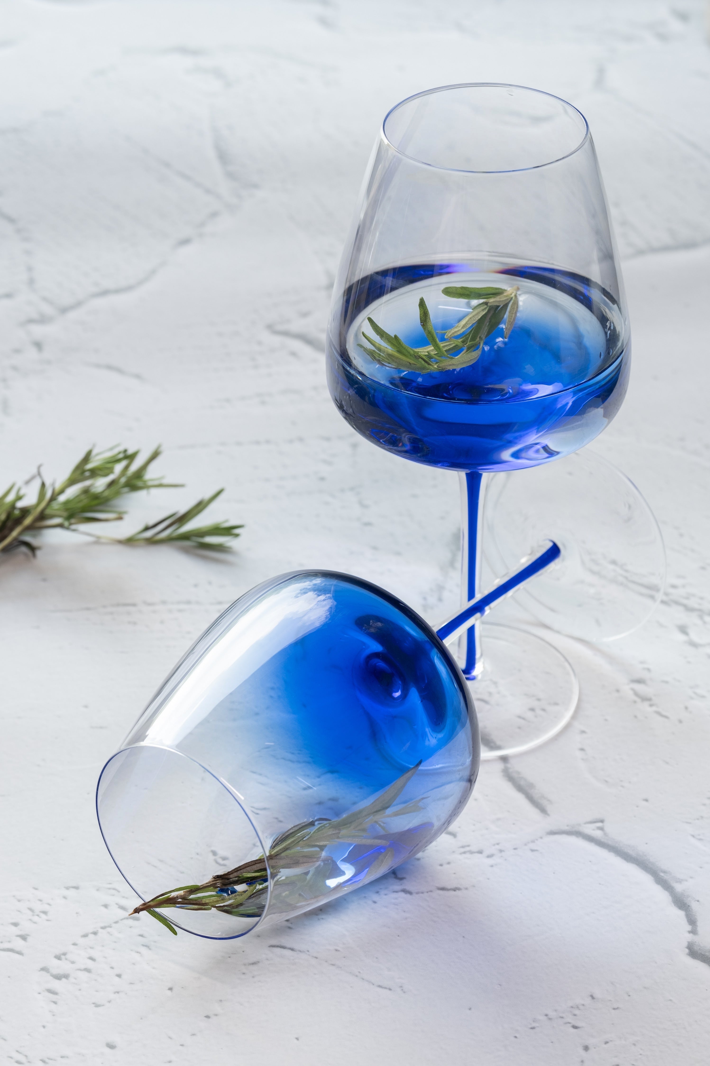 INVOKE elegant blue tinted wine glasses with clear stems and gradient blue bowls, perfect for modern barware.