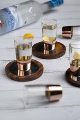 INVOKE copper banded shot glasses with lemon slices and wooden coasters, set of 4, clear glass with copper base.