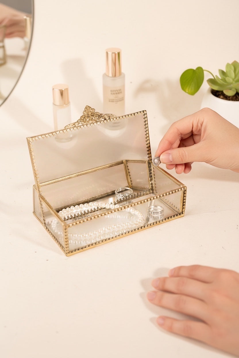 INVOKE decorative glass jewelry box with antique brass finish, holding pearl necklace and rings.