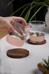 INVOKE Grit Whiskey Glasses with rose gold band and walnut coaster, clear glass tumblers for spirits.
