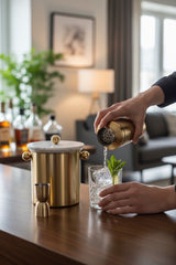 INVOKE luxury cocktail barware set with brushed gold shaker, jigger, and marble ice bucket with gold accents.