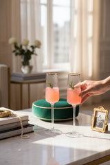 INVOKE fluted champagne flutes with gold rim and vertical ribbed texture, filled with pink champagne.