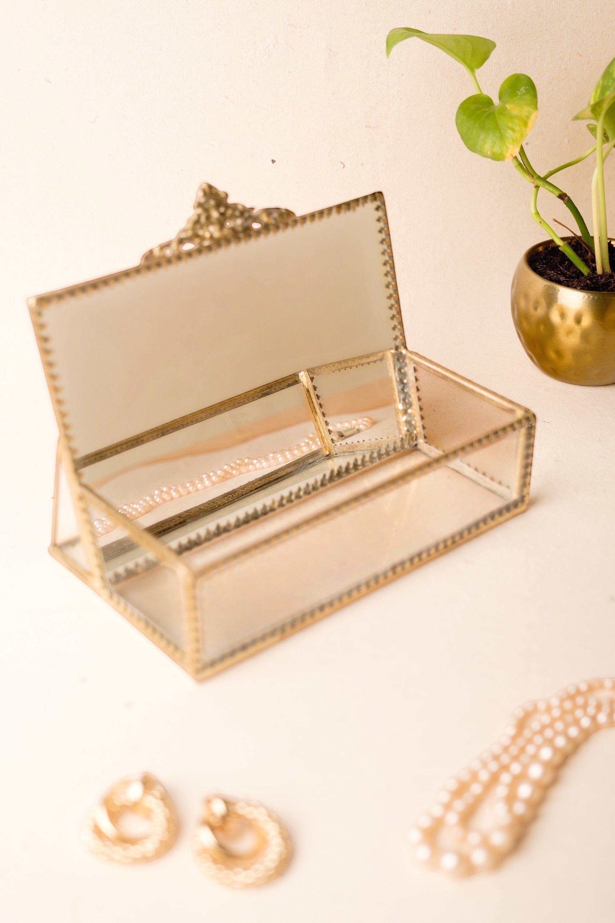 INVOKE decorative glass jewelry box with antique brass finish, hinged lid, and interior divider. Holds pearl necklace.