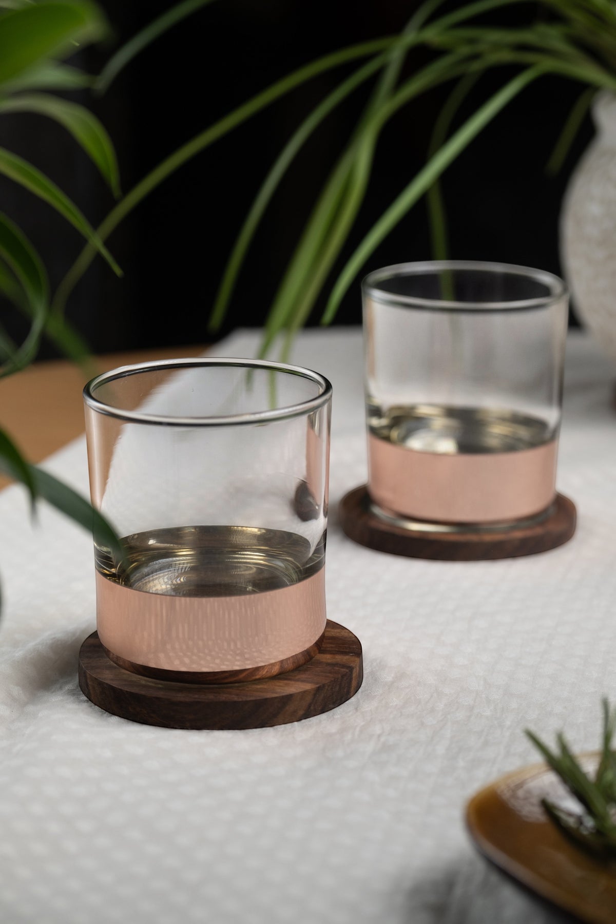 INVOKE Grit Whiskey Glasses with copper band and walnut coaster, clear glass tumblers for spirits.