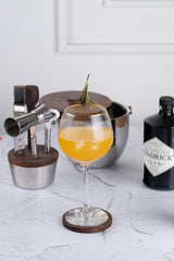 INVOKE Stainless Steel Barware Set with wooden accents, including shaker, jigger, ice bucket, and coasters.